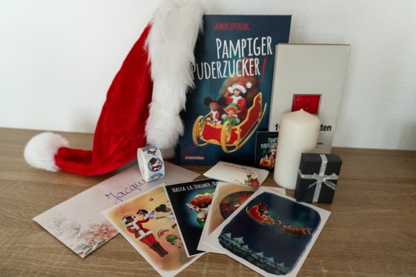 Das Buch "Pampiger Puderzucker!" von Jasmin Zipperling mit Goodies aus dem Bloggerpaket.
